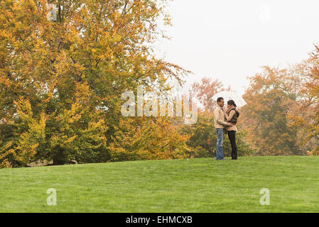 Paar stehend mit Schirm im park Stockfoto