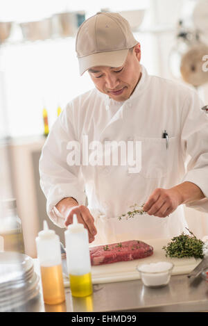 Koreanischen Koch würzen Fleisch in Küche Stockfoto
