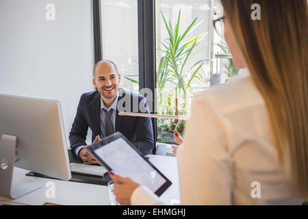 Kaukasische Geschäftsleute sprechen im Büro Stockfoto