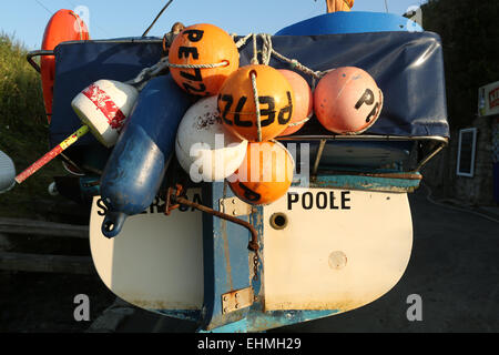 Bojen hängen von der Rückseite eines kleinen Fischerbootes in Dorset, Großbritannien Stockfoto