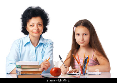 Enkelin mit ihrer Großmutter sitzt unter dem Tisch mit Büchern, die Sie betrachten. Stockfoto