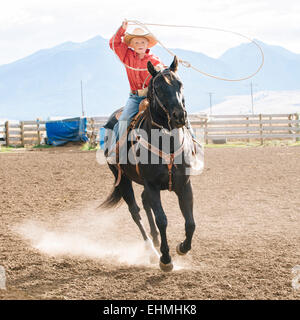 Kaukasische junge mit Lasso auf Pferd beim rodeo Stockfoto