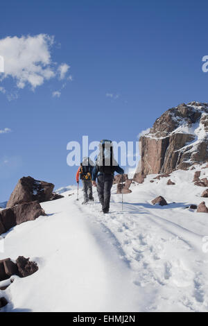 Hispanische Wanderer gehen auf verschneiten Bergen Stockfoto