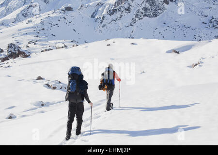 Hispanische Wanderer gehen auf verschneiten Bergen Stockfoto
