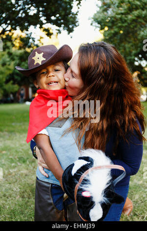 Mutter Sohn küssen für Halloween als Cowboy verkleidet. Stockfoto