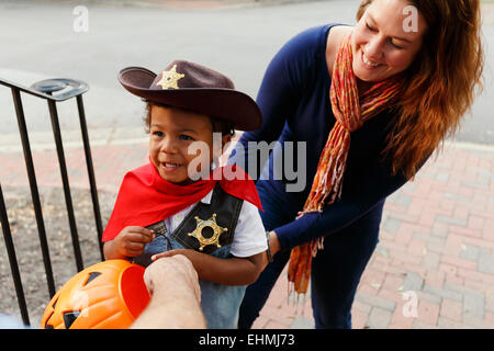 Mutter mit Sohn Trick für Halloween als Cowboy verkleidet. Stockfoto