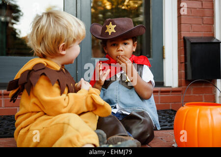 Jungen Kostüme Halloween Süßigkeiten essen Stockfoto