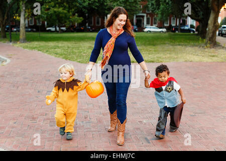 Mutter und Söhne Süßes oder Saures zusammen an Halloween Stockfoto