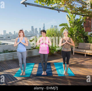 Frauen praktizieren Yoga zusammen auf städtischen Dach Stockfoto