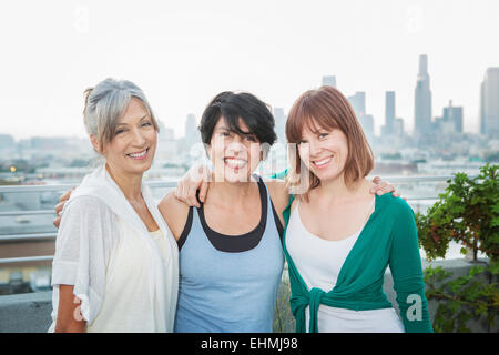 Frauen Lächeln zusammen auf städtischen Dach Stockfoto