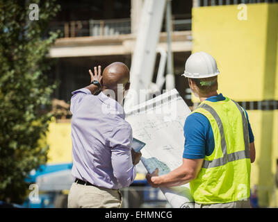 Geschäftsmann und Bau Arbeiter lesen Blaupausen auf Baustelle Stockfoto