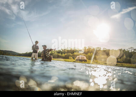 Kaukasische Vater und Sohn Angeln im Fluss Stockfoto