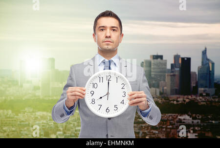 Geschäftsmann im Anzug hält mit 08:00 Uhr Stockfoto