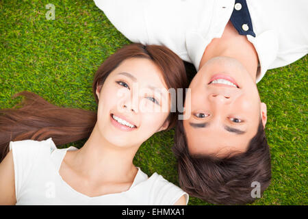Draufsicht des jungen Paares liegen zusammen auf dem Rasen Stockfoto