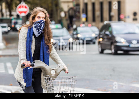 Frau reitet ein Fahrrad in einem städtischen Umfeld. Stockfoto