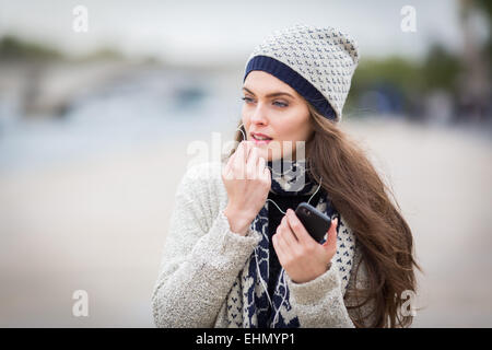 Frau mit ihrem Handy mit einer Freisprecheinrichtung. Stockfoto