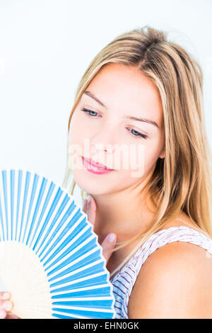 Frau, die ihr Gesicht mit einem Ventilator zu kühlen. Stockfoto