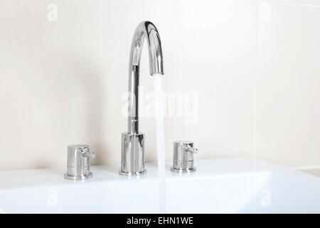 ein moderne Waschtisch mit glänzenden Wasserhahn aus dem Wasser läuft Stockfoto