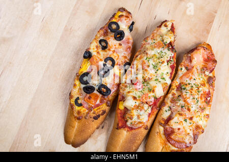 Assorti Bruscjetta mit Wurst, Käse, Tomate Fron große weiße Baguette auf hölzernen Hintergrund Stockfoto