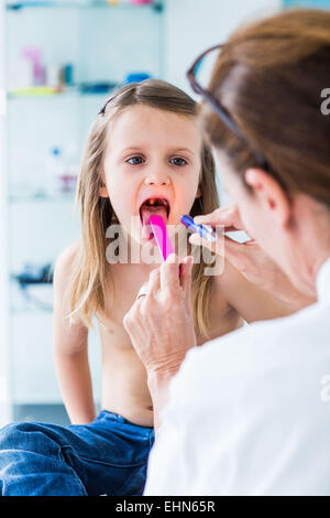 Arzt untersucht die Kehle eines 4 Jahre alten Mädchens. Stockfoto