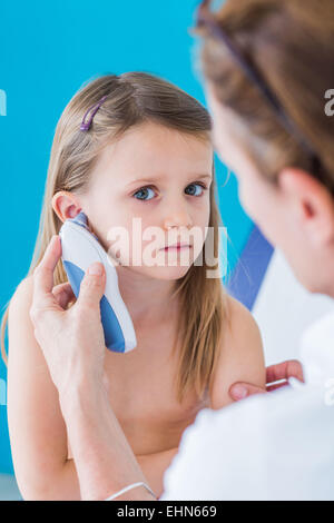 Arzt überprüft die Temperatur eines 4-jährigen Kindes mit einem Digitalthermometer Mittelohrchirurgie. Stockfoto