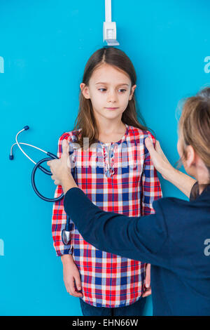Arzt messen der Höhe eines jungen Mädchens während einen Check-up. Stockfoto