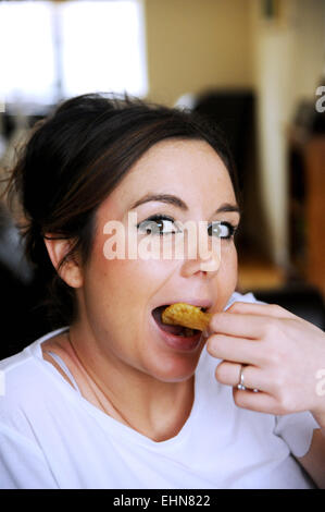 Junge Frau Essen Kartoffelchips Stockfoto