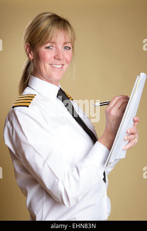 Weibliche Flugkapitän in Uniform und hält einen Stift Stockfoto