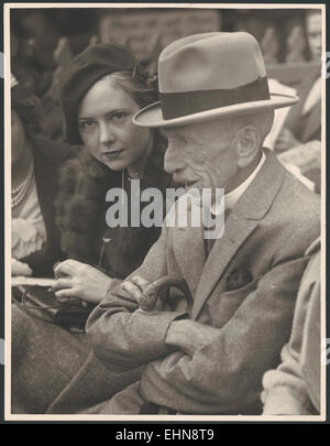 Billy Hughes, ehemaliger australischer Premierminister, wird mit seiner Tochter Helen Hughes auf dem Sydney Cricket Ground gesehen. Das Foto zeigt einen Moment der persönlichen Verbindung zwischen der prominenten politischen Persönlichkeit und seiner Familie vor dem Hintergrund eines der legendären Sportstätten Australiens. Stockfoto