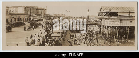 Menschen zu Fuß auf der Strandpromenade und sitzt auf der großen Ufermauer in Galveston, Texas Stockfoto