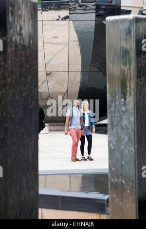 paar zu Fuß vorbei an Wasserspielen vor verspiegelten Planetarium im Millenium Square, Harbourside, Bristol im Mai Stockfoto