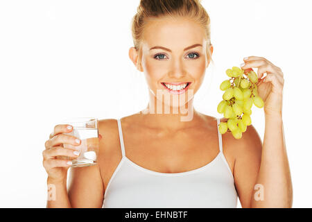Schöne Frau mit Wasser und Trauben Stockfoto