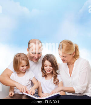 glückliche Familie mit Buch zu Hause Stockfoto