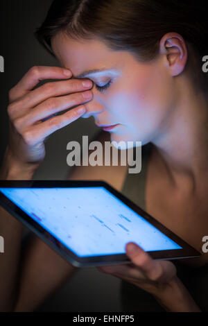 Frau bei der Arbeit, die unter Kopfschmerzen leiden. Stockfoto