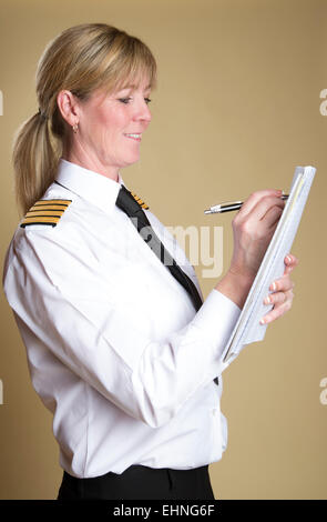 Weibliche Flugkapitän in Uniform und hält einen Stift Stockfoto