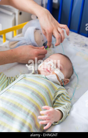 Baby von einer Bronchiolitis betroffen, im Krankenhaus in der pädiatrischen Abteilung des Krankenhauses von Angoulême, Frankreich, hier Rohr füttern. Stockfoto
