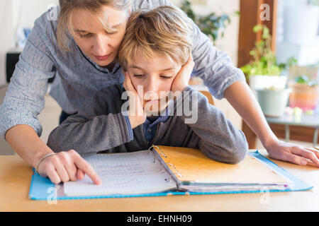 8 Jahre alter Junge Hausaufgaben mit seiner Mutter. Stockfoto