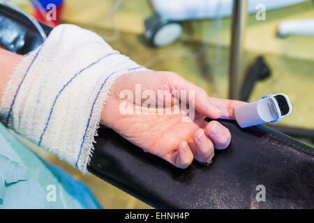 Nahaufnahme von einem Pulsoximeter am Finger des Patienten sich einer Operation unterziehen. Stockfoto