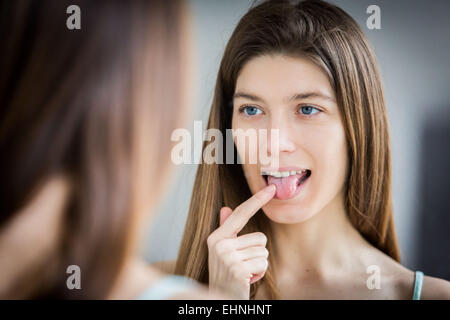 Frau Zunge in einem Spiegel zu prüfen. Stockfoto