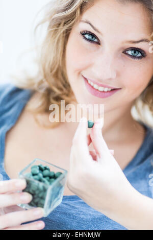 Frau, die Einnahme einer Tablets von Grünalgen. Stockfoto