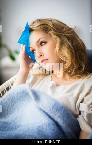 Frau mit einem kalt-warm Gel Pack Behandlung zur Linderung der Schmerzen. Stockfoto