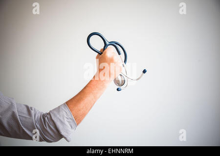 Hand mit einem Stethoskop. Konzeptbild auf die Herausforderung der Ärzte. Stockfoto