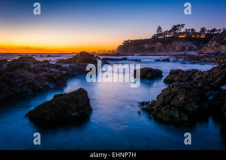 Langzeitbelichtung von Wasser und Felsen bei Sonnenuntergang, am kleinen Corona Beach in Corona del Mar, Kalifornien. Stockfoto