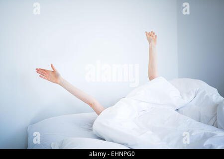 Frau aufwachen und stretching im Bett. Stockfoto