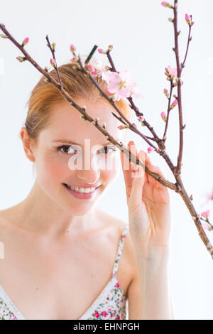 Frau vor einem Blooning Prunus Zweig. Stockfoto