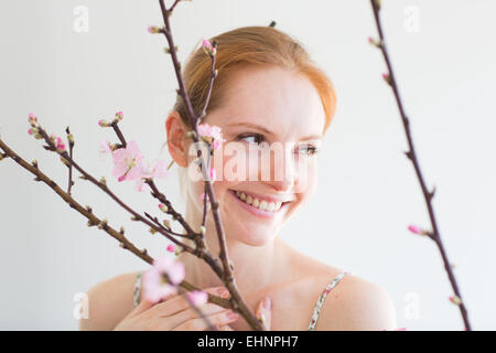 Frau vor einem Blooning Prunus Zweig. Stockfoto