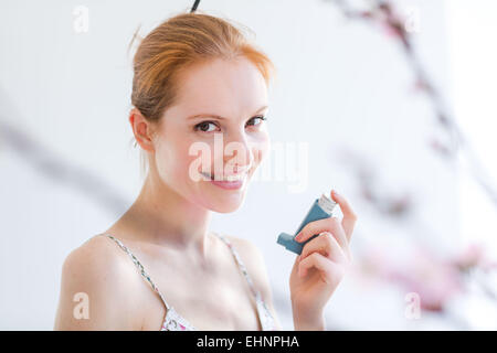 Frau mit einem Aerosol-Inhalator, der Erweiterung der Bronchien zur Behandlung von Asthma enthält. Stockfoto