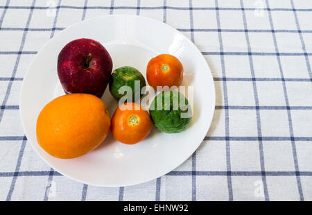 Sechs gemischte Früchte und Gemüse mit Kaffir Lime auf weißen Teller auf quadratischen Hintergrund platziert Stockfoto
