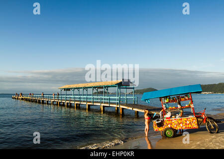 Hausierer und Pier am Strand Canasvieiras. Florianopolis, Santa Catarina, Brasilien. Stockfoto