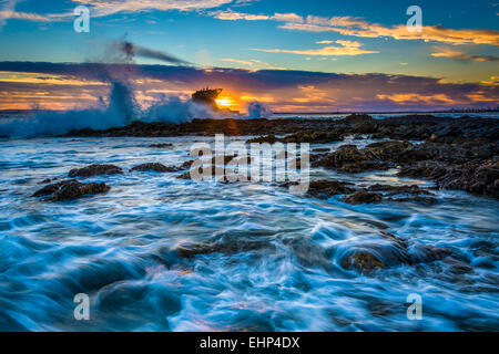 Wellen und Felsen bei Sonnenuntergang, am kleinen Corona Beach in Corona del Mar, Kalifornien. Stockfoto